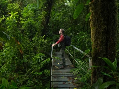 Een man staat op een brug in de Costa Ricaanse jungle