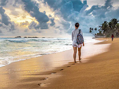 Vrouw wandelt langs het strand in Sri Lanka