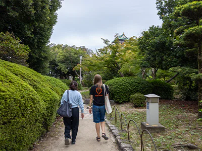 Japanse gids wandelt met een medewerker van TourCompass bij het kasteel van Osaka in Japan