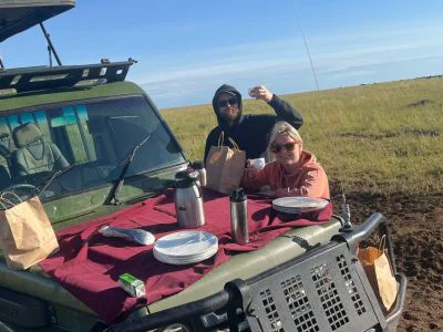 Twee mensen ontbijten op het safarivoertuig