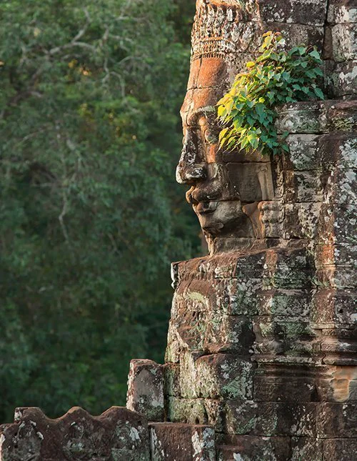 In steen uitgehouwen Boeddhahoofd bij de Bayon-tempel in Cambodja
