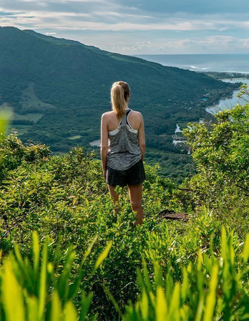 Een vrouw die uitkijkt over Le Morne Brabant op Mauritius